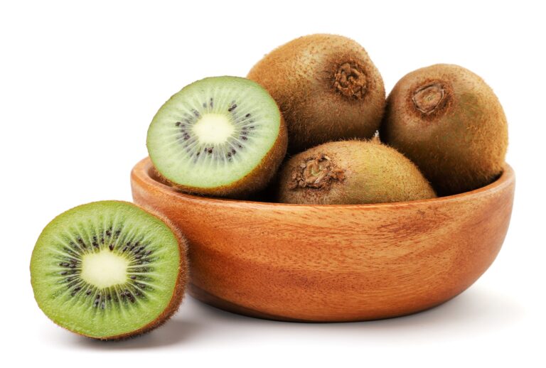 Kiwi fruit whole and half in a wooden plate on a white background. Isolated